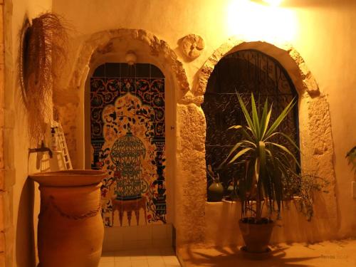 an entry to a building with a door and a plant at TenasBook Houch Yassmine in Erriadh