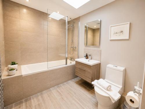 a bathroom with a tub and a toilet and a sink at Lucy's Lodge- Most Stylish Apartment On Vibrant Bishy Road with Free Parking in York