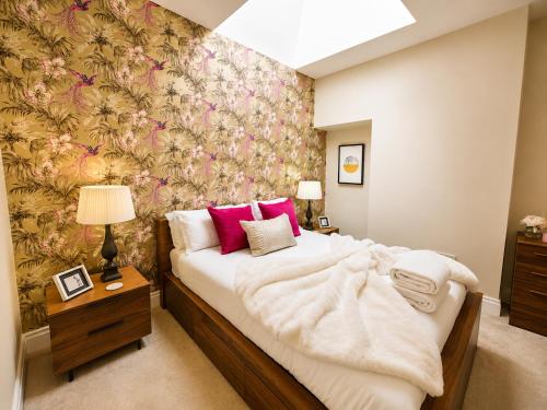 a bedroom with a large bed with a floral wallpaper at Lucy's Lodge- Most Stylish Apartment On Vibrant Bishy Road with Free Parking in York