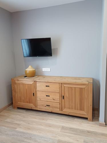 a flat screen tv on top of a wooden cabinet at Le Conty in Saint-Jorioz