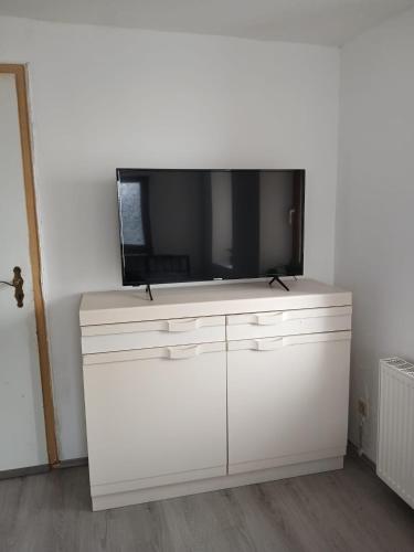 a flat screen tv on top of a white dresser at Apartment "Zum Rössel" Schönbrunn in Schönbrunn