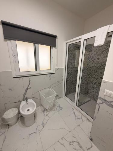 a white bathroom with a toilet and a shower at Vulcano Rooms 2 in Catania