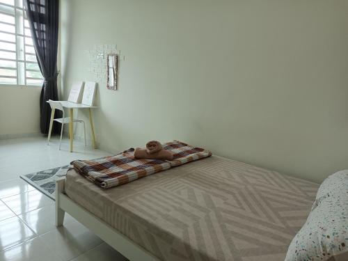 a teddy bear sitting on a bed in a bedroom at IB Indah Home Kangar in Kangar