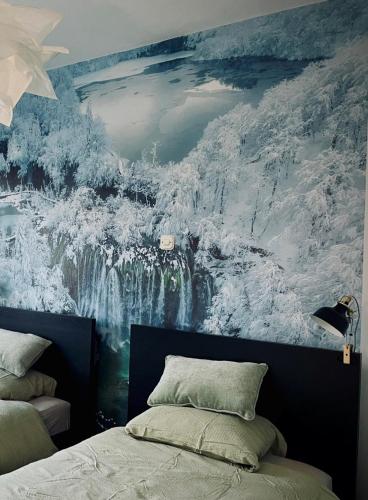 a bedroom with a large painting on the wall at Waterfall apartment in Plitvička Jezera