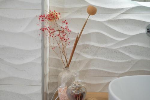 a glass vase with flowers in it on a table at Casa John Kos Apartment in Zipárion