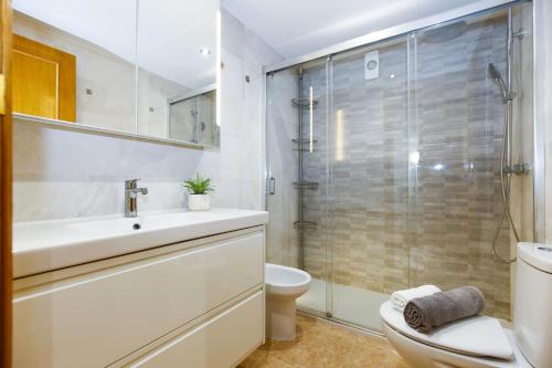 a bathroom with a toilet and a sink and a shower at Los Juncos HomeStay by Turismar in La Pineda