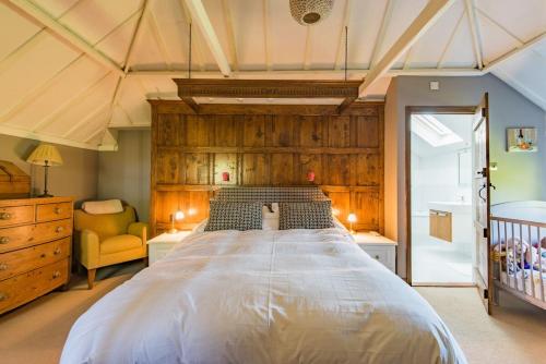 a bedroom with a large bed with a wooden headboard at Lanes End by Keepers Cottages in Woodchurch