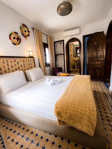 a bedroom with a large white bed in a room at Riad Zaitouna Chaouen in Chefchaouen