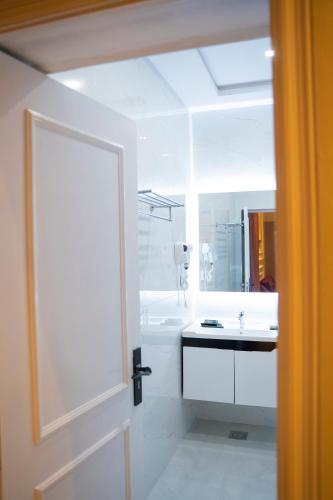 a white bathroom with a tub and a sink at The Edition Signature in Bahawalpur