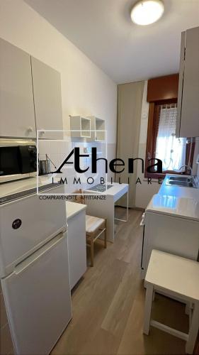 a kitchen with white cabinets and a white refrigerator at Sole in Grado