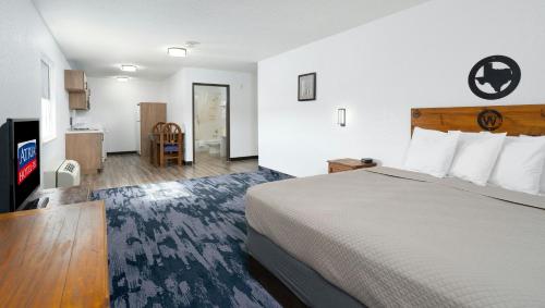 a hotel room with a bed and a flat screen tv at Atria Hotel and RV McGregor in McGregor