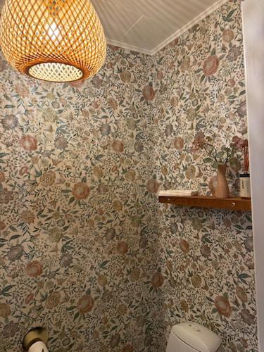 a bathroom with a flower patterned wall with a toilet at Humble Kro og Hotel in Humble
