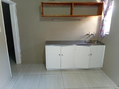 a bathroom with a white cabinet and a sink at Traquil Stays BnB in Klerksdorp