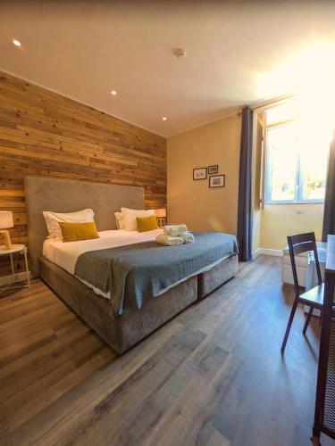 a bedroom with a large bed with a wooden wall at Casa do Salgueiral Douro in Peso da Régua
