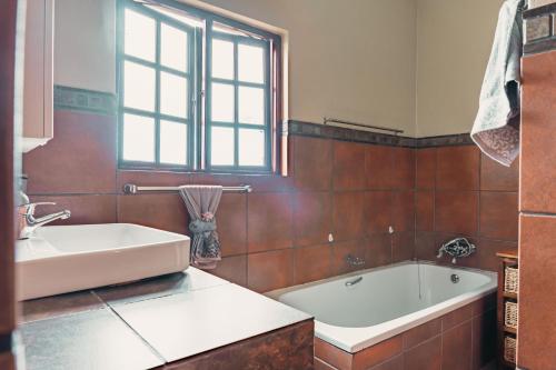 a bathroom with a white tub and a sink at Home on a Hill Accommodation in Tzaneen