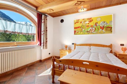 a bedroom with a bed and a large window at Chez Duclos Bionaz in Bionaz