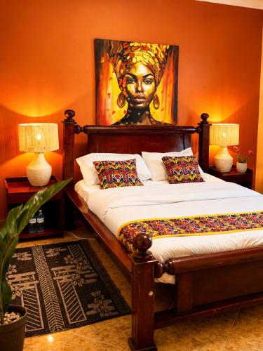 a bedroom with a bed with a portrait of a woman at Palm Star Motel in Fort Portal