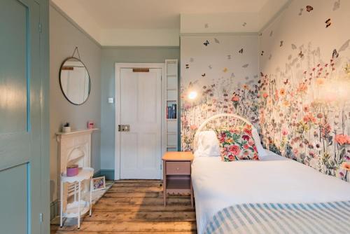 a bedroom with a bed and a desk and a table at Whispering Waves by Keepers Cottages in Hythe