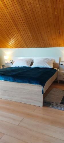 a bed in a bedroom with a wooden ceiling at Maróni Ház in Zalakaros