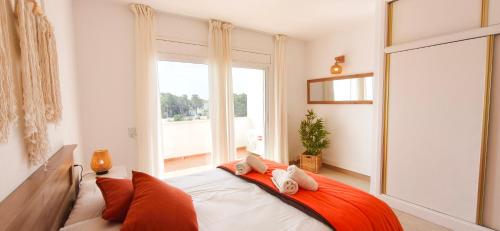 a bedroom with a bed with a large window at Duplex Ancla in L'Ametlla de Mar