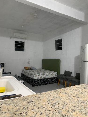 a kitchen with a sink and a bed in a room at Kitnet Céu e mar Saquarema in Saquarema