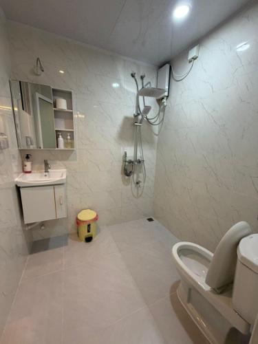 a bathroom with a shower and a toilet and a sink at Marine Holiday in Hulhumale