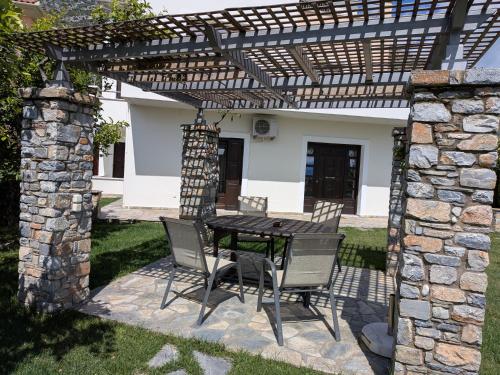 a patio with a table and chairs under a pergola at Homezie AGRIA in Agria