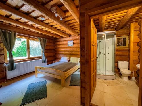 a log cabin bedroom with a bed and a shower at Craiasa Draganului in Poeni