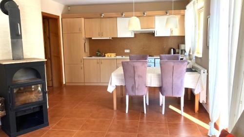 a kitchen with a table with purple chairs and a stove at Duży apartament w Karpaczu, cisza, parking, balkon lub taras, zieleń, plac zabaw, sklep 5min in Karpacz