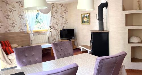 a living room with a table and chairs and a stove at Duży apartament w Karpaczu, cisza, parking, balkon lub taras, zieleń, plac zabaw, sklep 5min in Karpacz