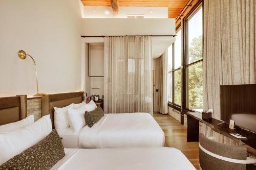ein Hotelzimmer mit zwei Betten und einem Schreibtisch in der Unterkunft Rivet House in Athens