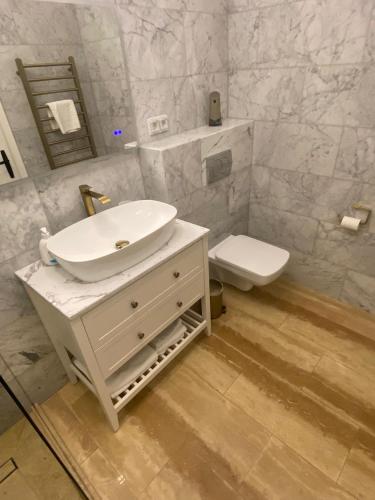 a white bathroom with a sink and a toilet at Central studio flat Cluj Napoca in Cluj-Napoca