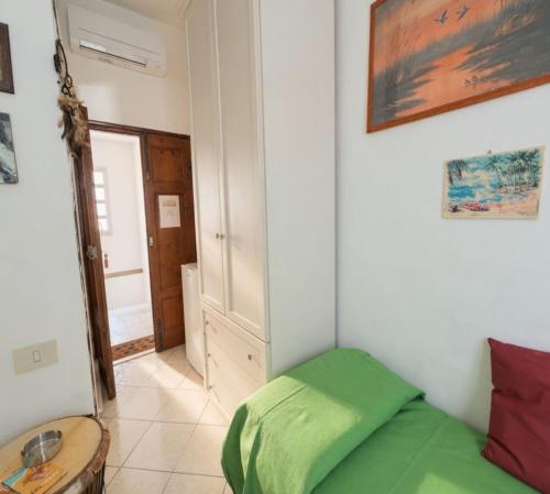 a small bedroom with a green bed and a table at La stanza di Giuly in Porto Santo Stefano