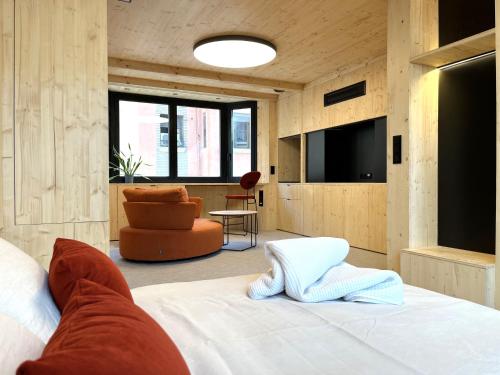 a bedroom with a bed and a couch and a chair at VTZ Minimal Suites in Zaragoza