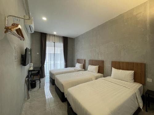 a hotel room with two beds and a television at HPY Hotel in Ipoh