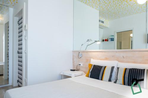 a bedroom with a white bed and a yellow ceiling at Hotiday Porto Cesareo Laguna in Porto Cesareo