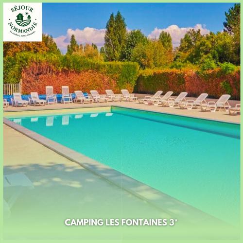 a swimming pool with chaises and chairs in a yard at Séjour Normandie - Mobilhome basic 3ch-6p avec climatisation dans l'Eure - 120 in Ivry-la-Bataille