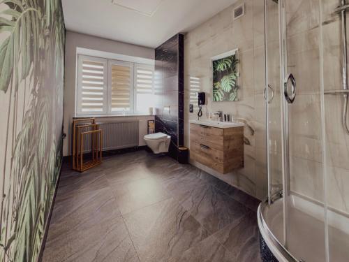 a bathroom with a shower and a toilet and a sink at Restauracja i Hotel KUBUŚ in Bełchatów