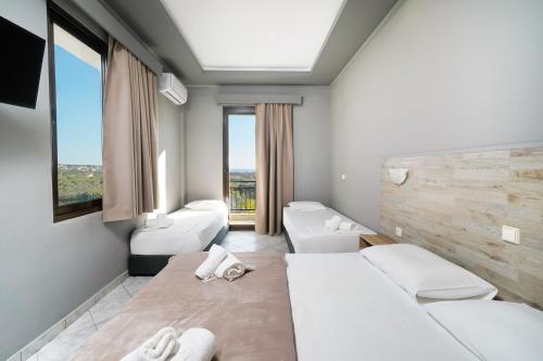 una camera da letto con due letti e una grande finestra di Meni Studios a Limenaria
