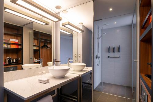 a bathroom with two sinks and a shower at Pestana Brussels Schuman in Brussels