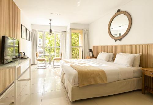 a bedroom with a large bed and a mirror at Feel Buenos Aires Apartments in Buenos Aires