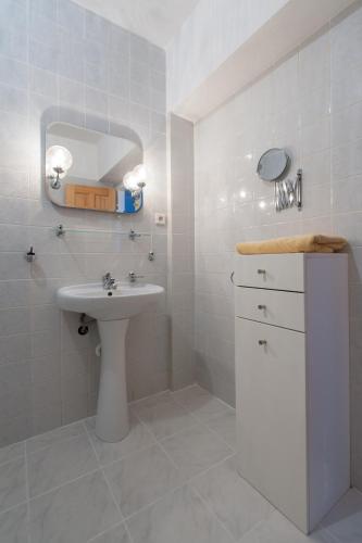 a white bathroom with a sink and a mirror at Czech Family Home in Český Krumlov