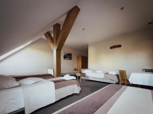 a hotel room with three beds and a table at Restauracja i Hotel KUBUŚ in Bełchatów