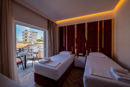 a hotel room with two beds and a balcony at Hotel Almar in Sarandë