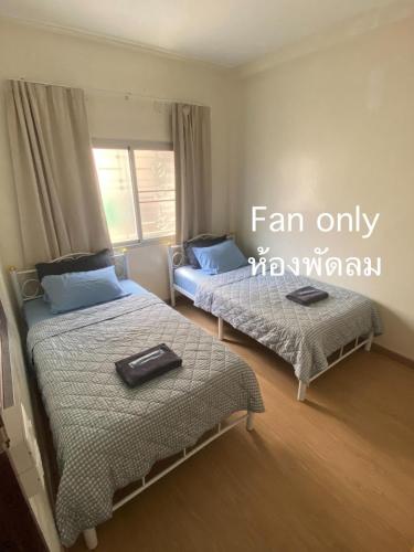 a room with two beds and a sign that reads fan only at PAMA'Pranakorn in Bangkok