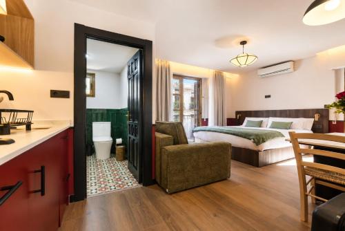 a hotel room with a bed and a kitchen and a bathroom at Casa Lavanda by Blossom Hotels in Granada