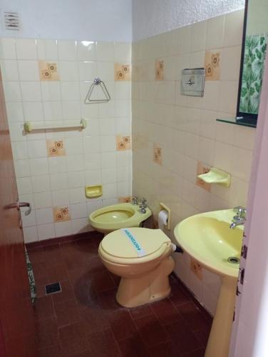 a bathroom with a toilet and a sink at Hotel El Colonial in San Antonio Oeste