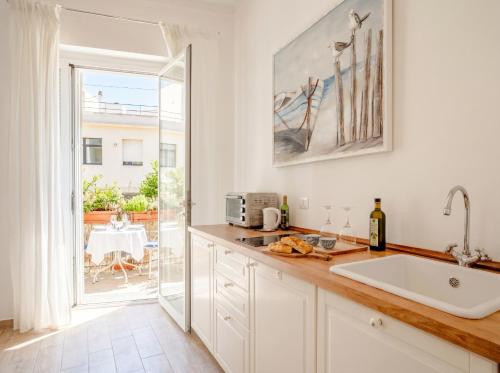 a kitchen with a counter with a sink and a window at Nido Blu in Polignano a Mare