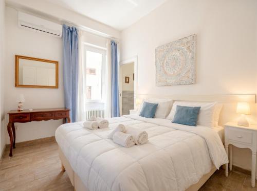 a bedroom with a large white bed with towels on it at Nido Blu in Polignano a Mare