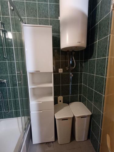 a bathroom with two trash cans and a shower at Apartmani Matjačić - Ugljan in Ugljan